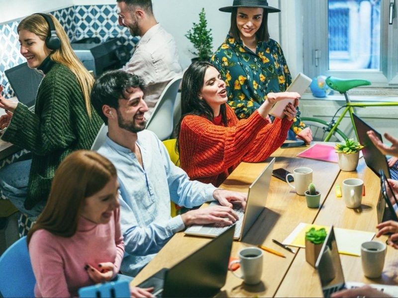 Team of Dubai coworkers using laptops and tablets in a shared workspace
