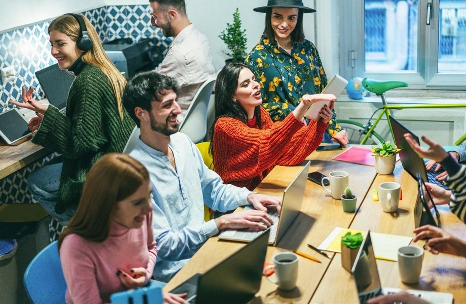 Team of Dubai coworkers using laptops and tablets in a shared workspace