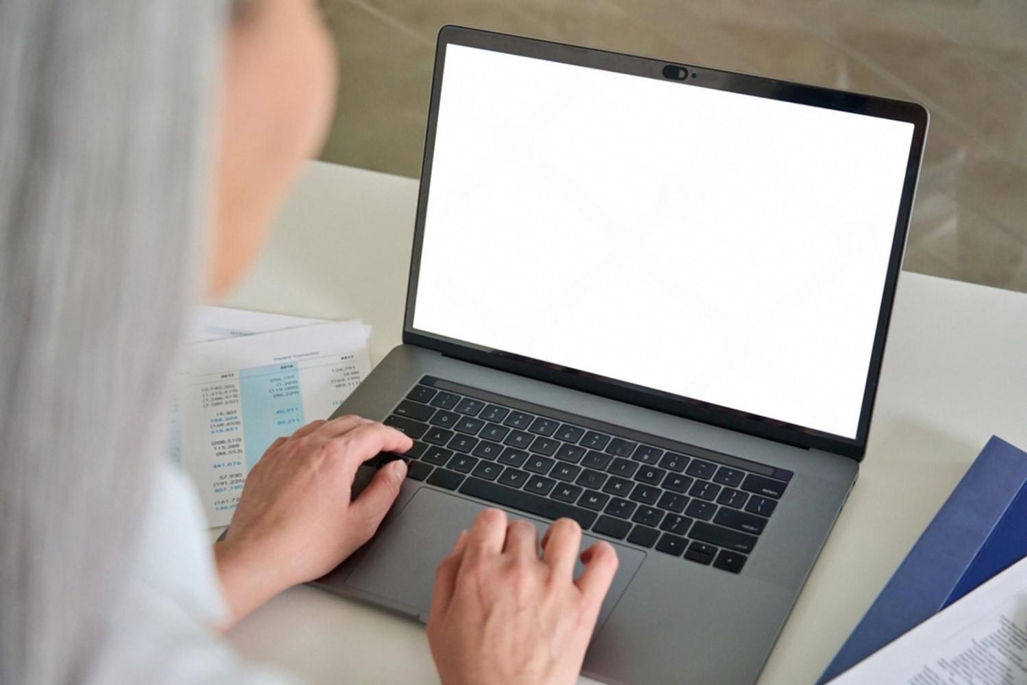 Accountant working on a laptop with financial reports in a Dubai office